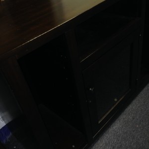 Entertainment Center #2. Tallish (maybe 3 feet high) and narrower than our other. This has a nice glassed in cabinet, with narrow shelves on the sides. Note the minor damage along the sides.